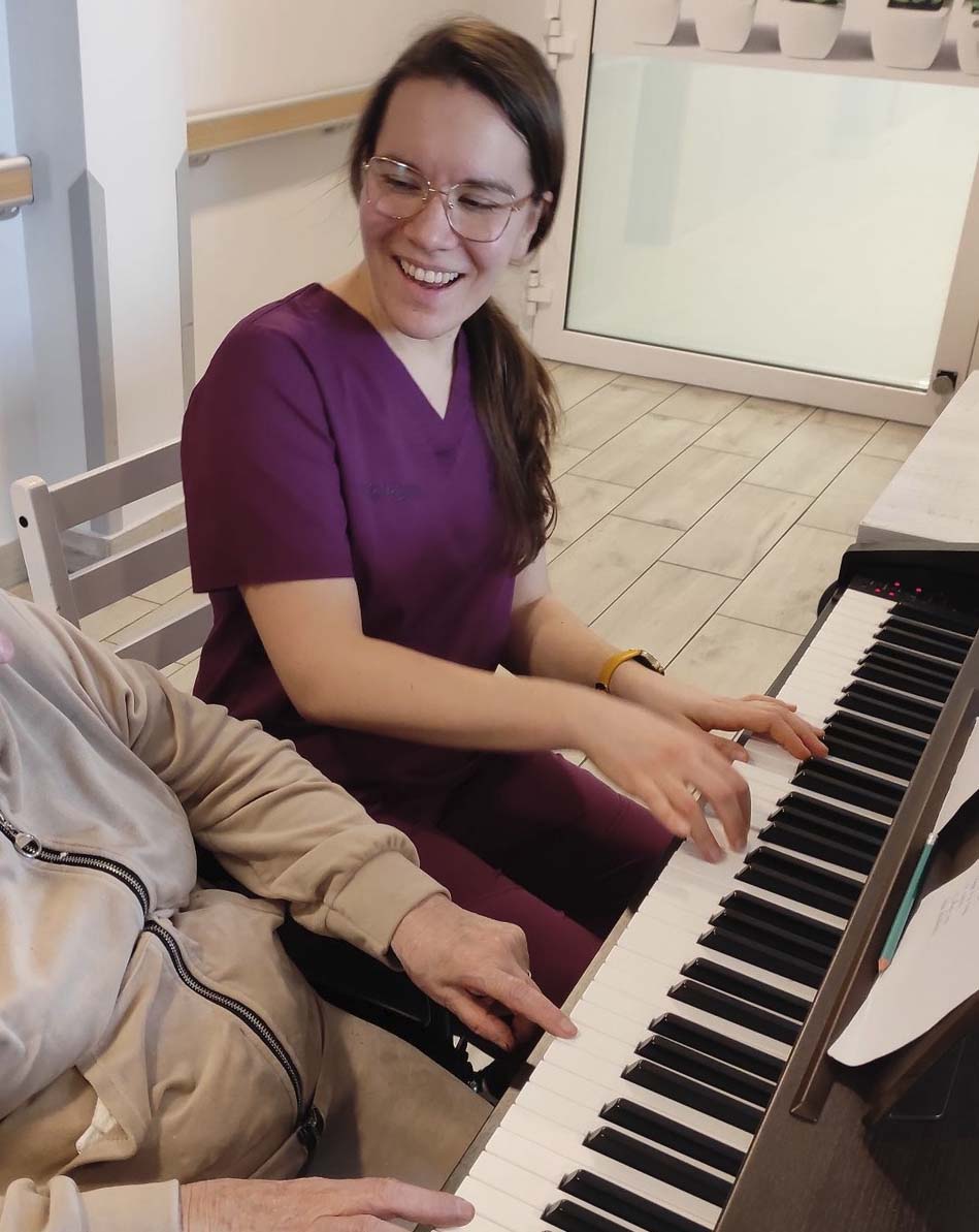 Seniorzy w Rytmie grają na pianinie z pacjentami